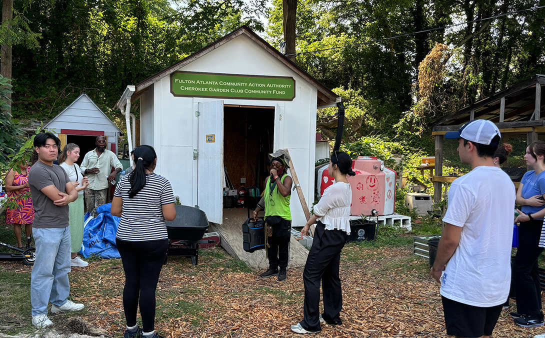 Students gather around an organization leader during a community-based learning course outing.