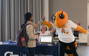 Buzz highfiving a student