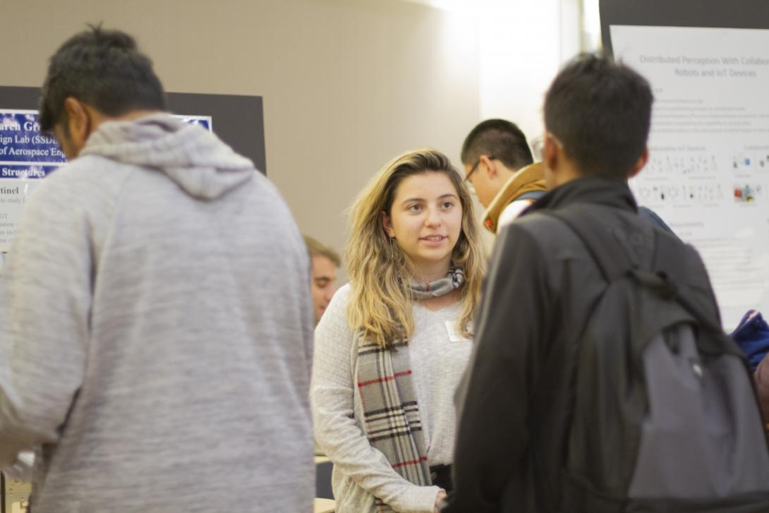 students talking at research fair