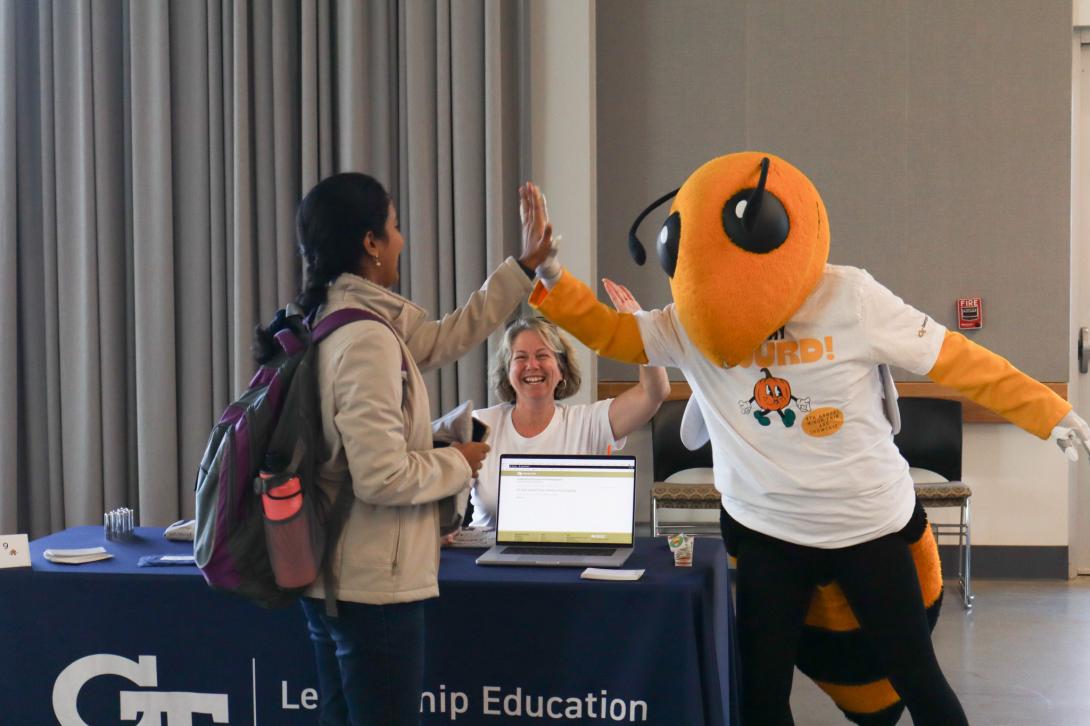 Buzz highfiving a student